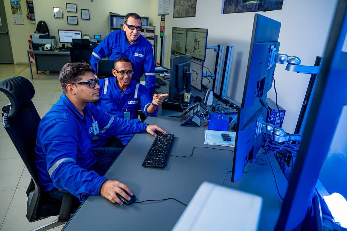 Woman and man wearing safety glasses examine a screen in a laboratory